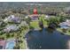 Aerial shot featuring a house by a scenic lake and a lush, expansive green lawn at 4404 Lake In The Woods Dr, Spring Hill, FL 34607