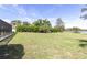 Expansive backyard lawn with view of lake and mature landscaping at 4404 Lake In The Woods Dr, Spring Hill, FL 34607