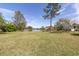 Expansive backyard view features a serene lake and lush greenery, providing a tranquil setting at 4404 Lake In The Woods Dr, Spring Hill, FL 34607