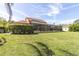View of the expansive lawn and screened-in pool at 4404 Lake In The Woods Dr, Spring Hill, FL 34607