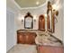 Custom bathroom features dual sinks with ornate mirrors and sconces, plus decorative wood cabinetry at 4404 Lake In The Woods Dr, Spring Hill, FL 34607