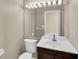 Neutral-toned bathroom with vanity, mirror, and toilet; bright vanity lighting at 4404 Lake In The Woods Dr, Spring Hill, FL 34607