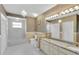 Elegant bathroom features a double vanity, granite counters, decorative lighting, and a tub with shower at 4404 Lake In The Woods Dr, Spring Hill, FL 34607