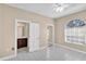 Neutral bedroom boasts tile flooring, an arched window with blinds, and an ensuite bathroom at 4404 Lake In The Woods Dr, Spring Hill, FL 34607