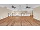 Large open bonus room featuring laminate flooring, ceiling fans, and a charming chandelier at 4404 Lake In The Woods Dr, Spring Hill, FL 34607