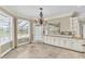 Bright dining area features a chandelier, tile floors, and natural light from the large window and door at 4404 Lake In The Woods Dr, Spring Hill, FL 34607