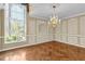 Elegant dining room showcases a decorative chandelier, large window, and herringbone wood floors at 4404 Lake In The Woods Dr, Spring Hill, FL 34607