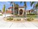 Inviting two-story home featuring a red roof, palm trees, arched entryway, and a well-manicured lawn at 4404 Lake In The Woods Dr, Spring Hill, FL 34607
