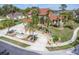 Beautiful home featuring a circular driveway, fountain, lush landscaping, and mature palm trees at 4404 Lake In The Woods Dr, Spring Hill, FL 34607