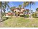 Lush front lawn of a home with mature palm trees and a sprawling yard at 4404 Lake In The Woods Dr, Spring Hill, FL 34607