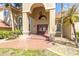 Elegant home entrance featuring arched windows, an ornate light fixture, and a brick-paved walkway at 4404 Lake In The Woods Dr, Spring Hill, FL 34607