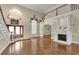 Bright living room with herringbone floors, marble fireplace, grand chandelier, and elegant staircase at 4404 Lake In The Woods Dr, Spring Hill, FL 34607