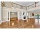 Open floor plan living room with herringbone wood floors, fireplace, and decorative columns at 4404 Lake In The Woods Dr, Spring Hill, FL 34607