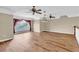 Expansive living area with wood floors, a large window, ceiling fans, and modern lighting at 4404 Lake In The Woods Dr, Spring Hill, FL 34607