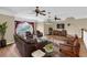 Inviting living room with leather seating, ceiling fans, and serene lake views at 4404 Lake In The Woods Dr, Spring Hill, FL 34607