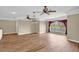 Spacious living room featuring ceiling fans, wood floors, and a large window with curtains at 4404 Lake In The Woods Dr, Spring Hill, FL 34607