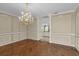 Elegant living room with beautiful wood floors, columns, and a view into the kitchen at 4404 Lake In The Woods Dr, Spring Hill, FL 34607