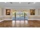 Spacious living room features hardwood floors, neutral walls, and sliding glass doors to the outdoor pool at 4404 Lake In The Woods Dr, Spring Hill, FL 34607