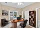 Home office with built-in bookcase, modern desk, leather chair, and sliding glass doors with a pool view at 4404 Lake In The Woods Dr, Spring Hill, FL 34607