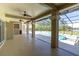 Open patio with ceiling fans, decorative pillars, and an extended view of the screened in pool and lake at 4404 Lake In The Woods Dr, Spring Hill, FL 34607