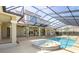 Screened-in pool and spa with an attached house overlooking the backyard and covered patio area at 4404 Lake In The Woods Dr, Spring Hill, FL 34607