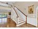 Elegant staircase with wood and white trim features herringbone floors and natural light at 4404 Lake In The Woods Dr, Spring Hill, FL 34607