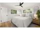 Cozy bedroom with a queen bed, wood floors, bright windows, and a modern ceiling fan at 4517 S Hale Ave, Tampa, FL 33611