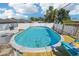 Backyard featuring a fenced in above ground pool with a wood deck and chair at 4900 Colonnade Ave, Holiday, FL 34690