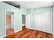 A mint colored bedroom with wood floors and a door to the bathroom at 5704 Bratton Dr # 2, Tampa, FL 33617