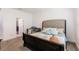 This bedroom features neutral decor, an upholstered headboard and a gray rocking chair at 733 Garden Oaks Sq, Seffner, FL 33584