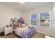 Bright bedroom with a patterned bedspread, a nightstand and natural light from the windows at 733 Garden Oaks Sq, Seffner, FL 33584
