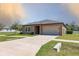 Inviting home featuring a concrete driveway leading to a two-car garage and a well-kept lawn at 733 Garden Oaks Sq, Seffner, FL 33584