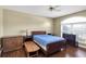Bedroom with hardwood floors, ceiling fan, dresser, and large arched window at 7472 Clearmeadow Dr, Spring Hill, FL 34606