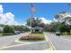 Community entrance featuring an American flag and guard house, for active adult living at 7472 Clearmeadow Dr, Spring Hill, FL 34606