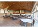 Spacious event space featuring vaulted wood ceilings, large windows, and ample seating for gatherings at 7472 Clearmeadow Dr, Spring Hill, FL 34606