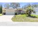 Single story home with an attached garage, well maintained lawn, and a lovely palm tree in the front yard at 7472 Clearmeadow Dr, Spring Hill, FL 34606