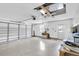 Spacious two car garage with epoxy flooring, ceiling fan, and storage cabinets at 7472 Clearmeadow Dr, Spring Hill, FL 34606