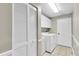 Bright laundry room with tile floor, white washer and dryer, cabinets and closet at 7472 Clearmeadow Dr, Spring Hill, FL 34606