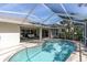 Screened pool with brick deck, outdoor seating, and lush landscaping at 7472 Clearmeadow Dr, Spring Hill, FL 34606