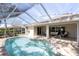Sparkling screened pool with brick deck and an outdoor seating area at 7472 Clearmeadow Dr, Spring Hill, FL 34606