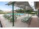 Resort-style pool area with abundant lounge chairs, tables, umbrellas, and a relaxing atmosphere at 7472 Clearmeadow Dr, Spring Hill, FL 34606
