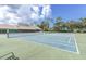 Well-maintained tennis courts surrounded by lush landscaping and a clear blue sky at 7472 Clearmeadow Dr, Spring Hill, FL 34606