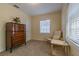 Carpeted bedroom with an antique dresser, white door, chair and accent table at 812 W Kentucky Ave, Tampa, FL 33603