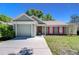 Charming single Gathering home with a well-manicured front yard and colorful red window shutters at 8217 Natchez St, Tampa, FL 33637