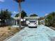 Exterior showcasing the blue driveway, garage, and mature trees at 9741 Scenic Dr, Port Richey, FL 34668