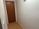View of hallway featuring hardwood floors and wood door at 9741 Scenic Dr, Port Richey, FL 34668