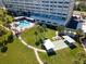 Aerial view showcasing the community pool, shuffleboard court, and lush landscaping at 100 Bluff View Dr # 409C, Belleair Bluffs, FL 33770