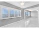 Open living room with bright windows offering a peek of the water and white tiled floor at 100 Bluff View Dr # 409C, Belleair Bluffs, FL 33770