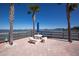 Inviting waterfront outdoor seating area with beautiful views, featuring a table, benches, and palm trees at 100 Bluff View Dr # 409C, Belleair Bluffs, FL 33770