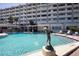 Community pool with a dolphin statue and building in the background at 100 Bluff View Dr # 409C, Belleair Bluffs, FL 33770